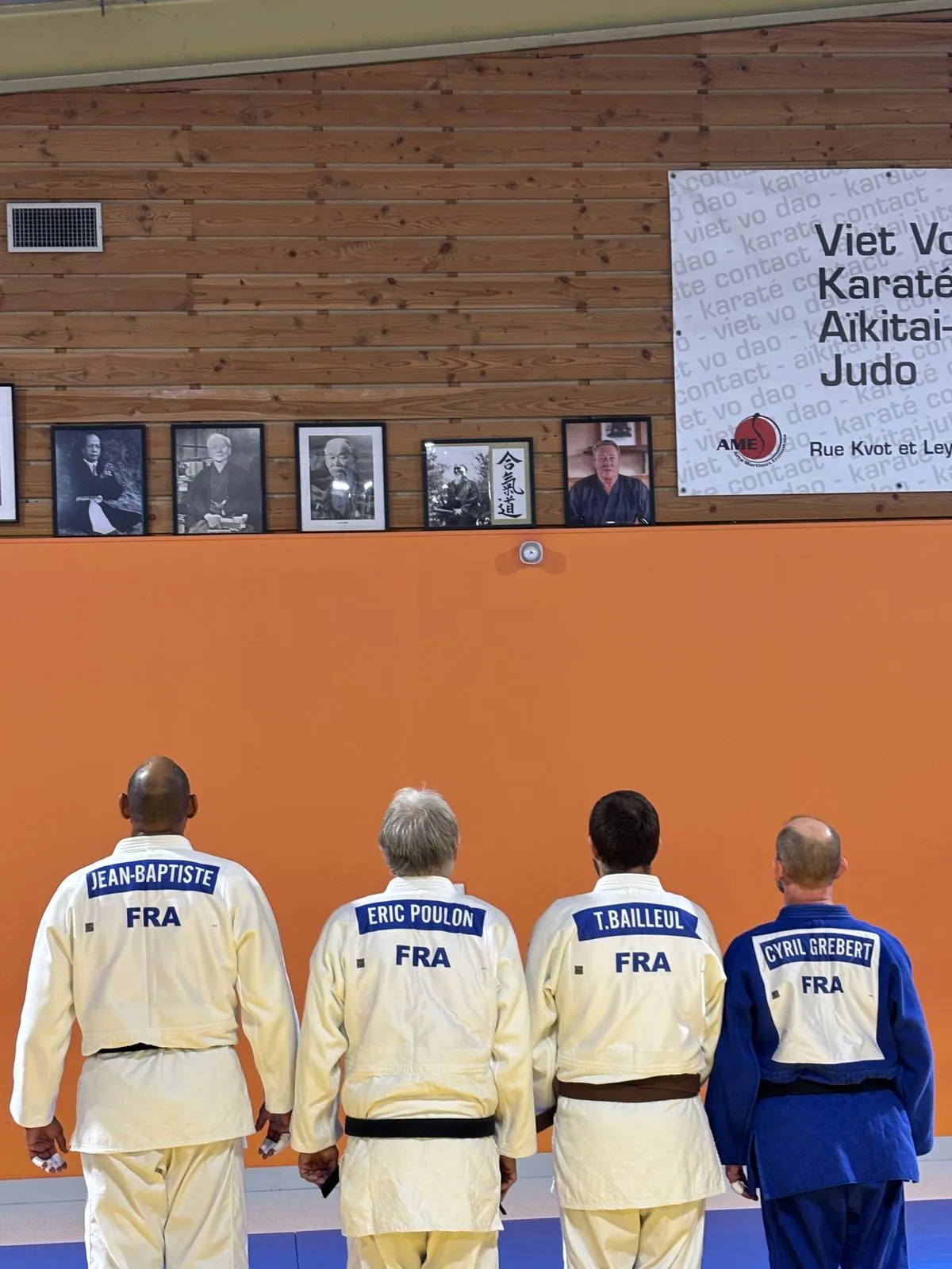 Judokas du club AME-JUDO devant les portraits des maîtres